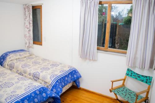 1 dormitorio con 1 cama, 1 silla y 1 ventana en La serena en San Carlos de Bariloche