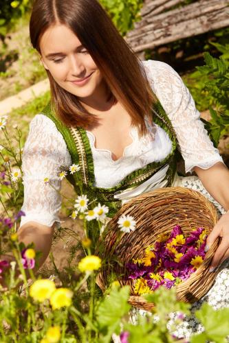 a woman is holding a basket of flowers at Berghotel Sonnenklause in Sonthofen