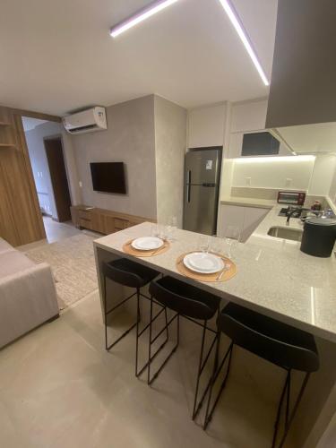 a kitchen with a island with two plates on it at Apartamento novo de alto padrão e aconchegante#224 in Brasilia