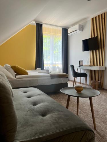 a hotel room with two beds and a table at Aventurin House *** in Révfülöp