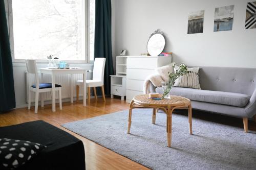 a living room with a couch and a table at City Center Coziest Studio in Tampere