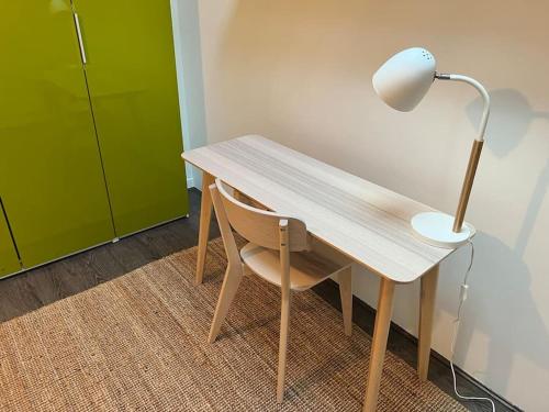 a wooden desk with a lamp and a chair at Superbe appartement avec cheminée in Fontainebleau