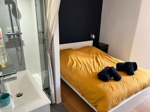 a bedroom with a yellow bed with a glass shower at Superbe appartement avec cheminée in Fontainebleau