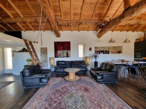 uma sala de estar com mobiliário de couro e uma mesa em Mas Montet chez Raphael em Valleraugue