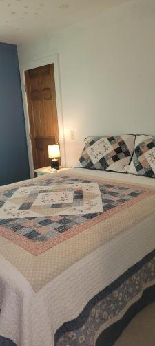 uma cama com uma colcha num quarto em Pleasant Place II Victor Countryside em Victor