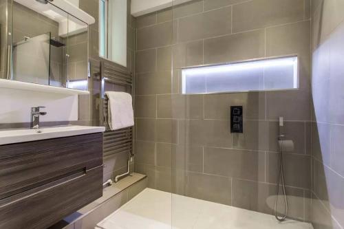 bagno con doccia, lavandino e specchio di Canal-side apartment in Shoreditch a Londra