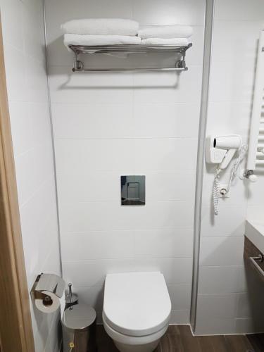 Baño pequeño con aseo blanco y toallas en ORBI PALACE room 556, en Bakuriani