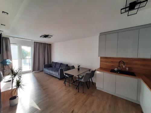 a kitchen and living room with a couch and a table at Apartament Nowa letnica in Gdańsk