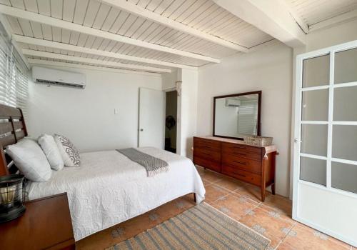 um quarto com uma cama, uma cómoda e um espelho em CASA BONITA em Maunabo