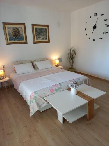 ein Schlafzimmer mit einem großen Bett und einer Uhr an der Wand in der Unterkunft App Ruzica in Crikvenica