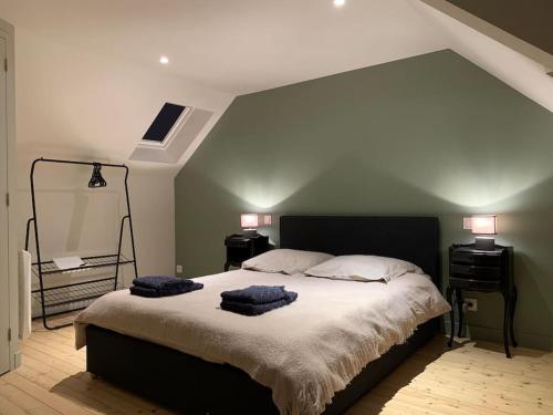 a bedroom with a large bed with two pillows on it at Robert's Family Petite Maison de Ville in Plancoët