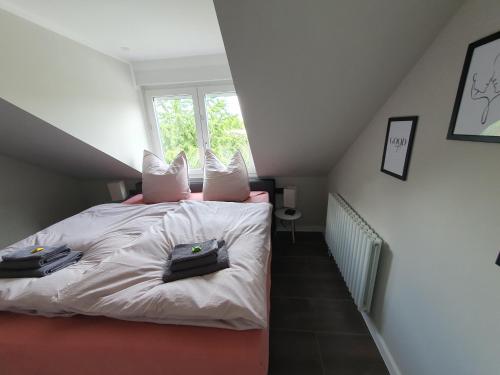 ein Schlafzimmer mit einem Bett mit zwei Kissen darauf in der Unterkunft Neumühler Hof - moderne Ferienwohnung "Janica" mit ruhiger Lage zum Garten raus mit kostenfreien Wlan und Netflix in Schwerin