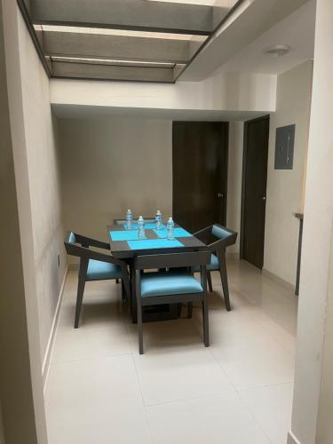 a dining room with a table and blue chairs at Suites San Luis in Mazatlán
