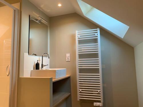 a bathroom with a sink and a mirror at Robert's Family Petite Maison de Ville in Plancoët