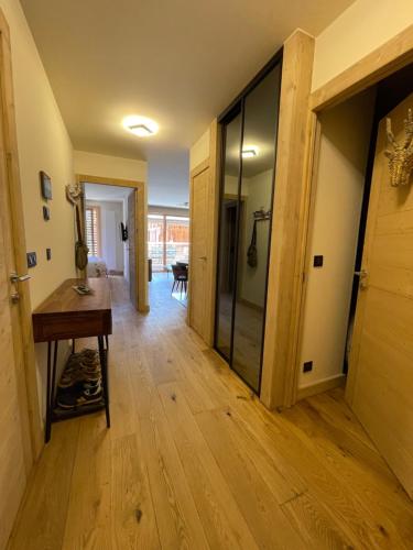 a hallway with wood floors and a glass door at GESPERE LE STELLA in Les Gets