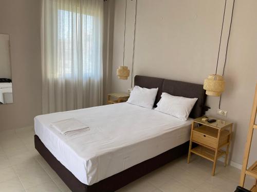 a bedroom with a large white bed with two pillows at Erato Apartments in Petalidhion
