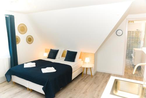 1 Schlafzimmer mit einem großen Bett und einem Badezimmer in der Unterkunft Raba92 Apartman House in Győr