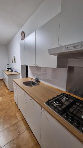uma cozinha com armários brancos e um forno com placa de fogão em Orio Welcome em Grassobbio