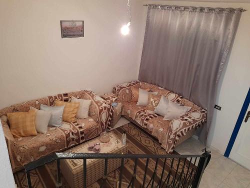 ein Wohnzimmer mit einem Sofa, einem Sofa und einem Stuhl in der Unterkunft Maison à Hergla, Sousse, Tunisie in Harqalah