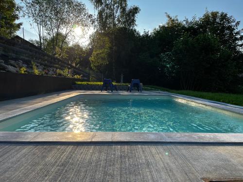 a swimming pool with two chairs in a yard at Chata Vojtkoland 
