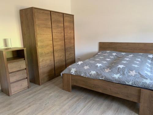 um quarto com uma cama e um armário de madeira em Ferienwohnung Malisa em Bad Bibra