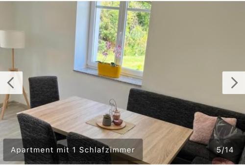einen Holztisch und Stühle in einem Zimmer mit Fenster in der Unterkunft Ferienwohnung Malisa in Bad Bibra