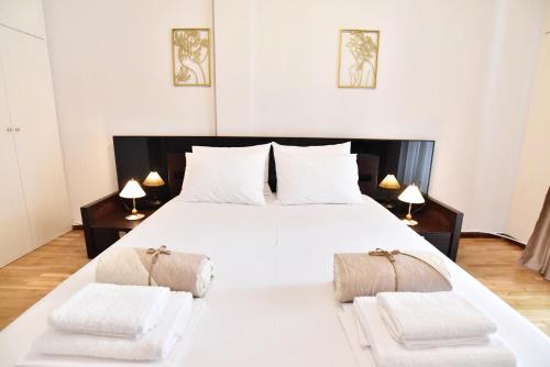 um quarto com uma grande cama branca e 2 cadeiras em Downtown Apartment 10 em Kavala