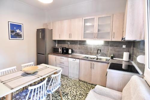 a small kitchen with a table and a refrigerator at Downtown Apartment 10 in Kavála