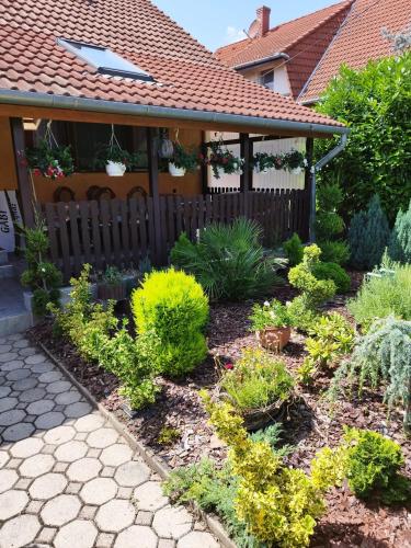 un jardín frente a una casa con plantas en Gabi vendégház en Balatonkeresztúr