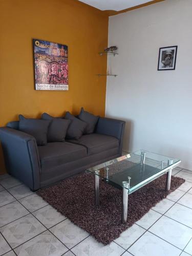 a living room with a couch and a glass coffee table at Hotel Casa Juanita in Puerto Escondido