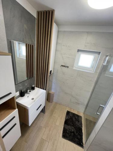 a bathroom with a white sink and a shower at Przystań na Dobrej in Kopalino