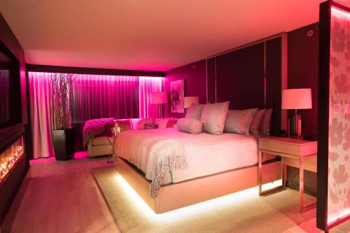 a pink bedroom with a bed and a fireplace at Sheraton Niagara Falls in Niagara Falls