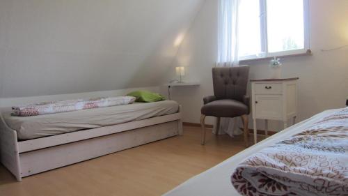 a bedroom with a bed and a chair and a window at Csaford Lodge in Felsőhegy