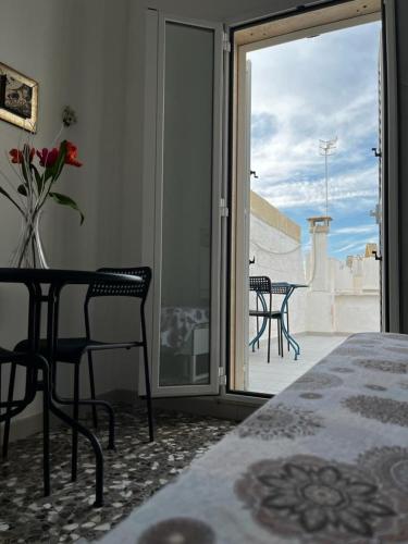 a room with a table and chairs and a balcony at La Dimora di Nonna Lucia in Polignano a Mare