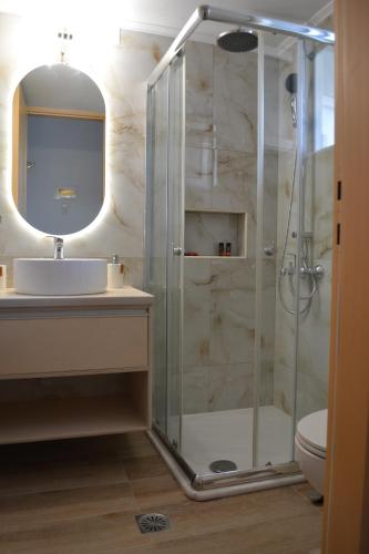 a bathroom with a glass shower and a sink at Melina's House in Stalos