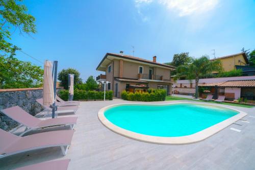 a swimming pool in front of a house at Bedda Mia Etna House B&B in Trecastagni