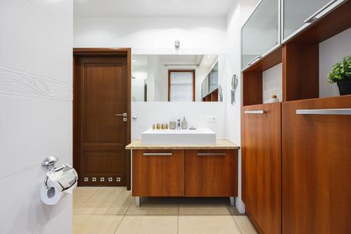 La salle de bains est pourvue d'un lavabo et d'un miroir. dans l'établissement White Sea - Neptun Park by OneApartments, à Gdańsk