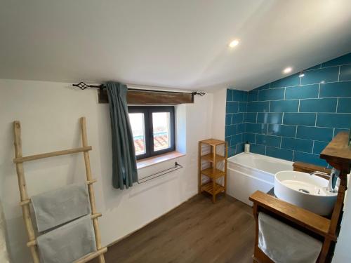 a bathroom with a tub and a sink and a window at Authentique Maison de village avec Vue in Réauville