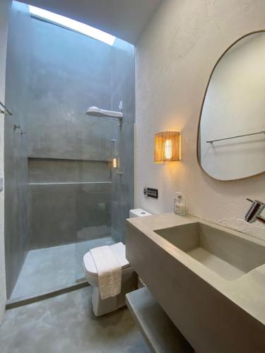 a bathroom with a shower and a sink and a mirror at Lotus Patacho in Pôrto de Pedras