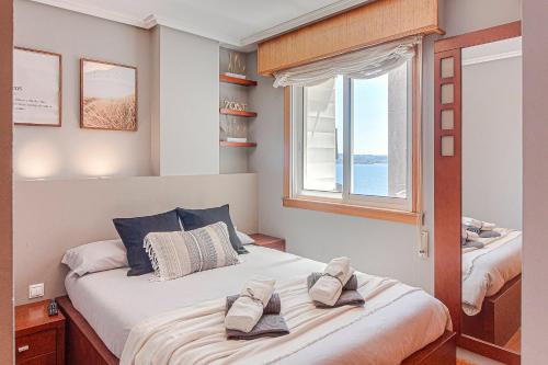 a bedroom with two beds and a window at San Amaro Beach 2 by TheBlueWaveApartmets com in A Coruña