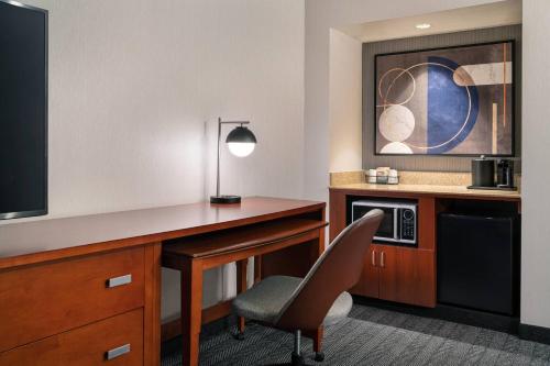 a hotel room with a desk and a chair at Courtyard Seattle Southcenter in Tukwila