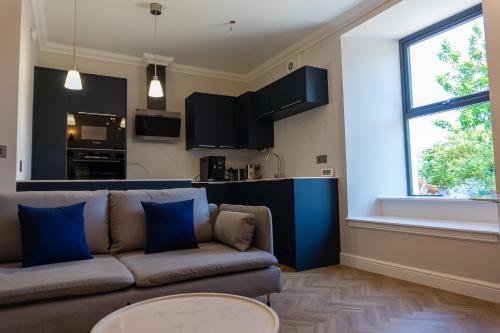 a living room with a couch and a kitchen at Oban Apartments in Oban