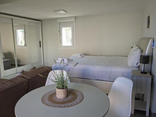 Ethos Apartment 2 في ني بيراموس: غرفة معيشة مع أريكة وطاولة وسرير