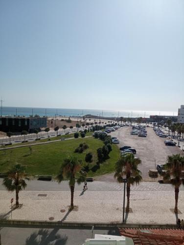 a view of a parking lot with palm trees at Apartamento Costa Azul in Costa da Caparica