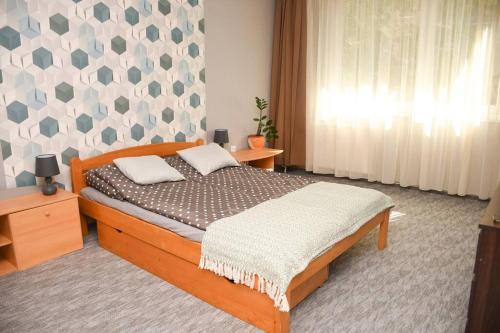 een slaapkamer met een bed met een houten bedframe bij Dóra apartman best location & free parking in Debrecen