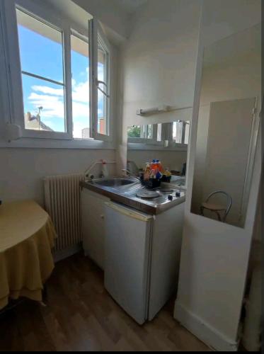 une petite cuisine avec un évier et une cuisinière dans l'établissement Studio centre ville, à Amiens