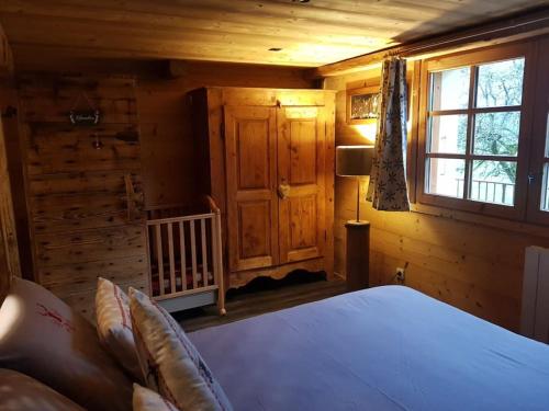 une chambre avec un lit dans une cabane en rondins dans l'établissement Appartement cosy aux Aravis (Clusaz/Grand-Bornand), à Entremont