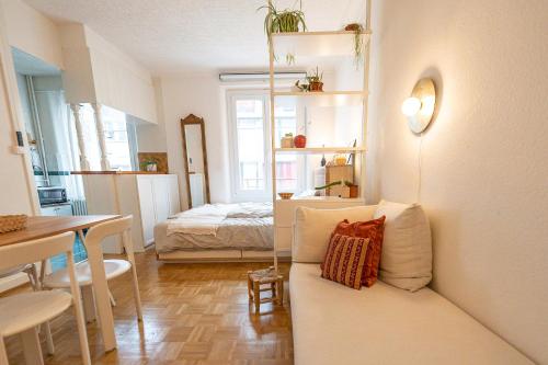 sala de estar con sofá y dormitorio en Beautiful central apartment steps from lake and water jet, en Ginebra