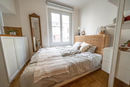 a bedroom with a large bed with a large window at Beautiful central apartment steps from lake and water jet in Geneva