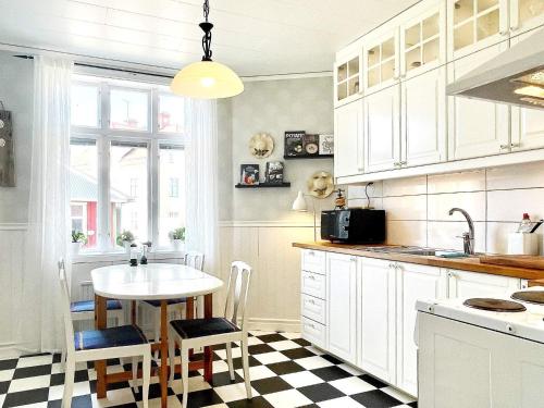 cocina con armarios blancos, mesa y sillas en Holiday home Södra vi, en Södra Vi
